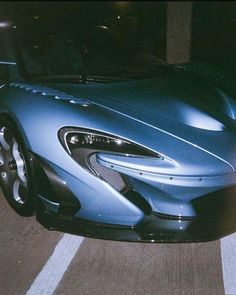 a blue sports car is parked on the street