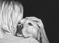 black and white photograph of a woman holding a dog's head in her arms