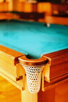 a pool table with a blue cloth on it and a net hanging from the top