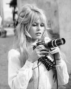 French actress Brigitte Bardot holds a camera during a break in filming, 1965. It's difficult for anyone who was not alive at the time to grasp the galvanizing effect that Bardot had as an actress and as a sex symbol on moviegoers around the world in the 1950s and early 1960s. Click the link to see the young Bardot in a series of pictures from our archive — most of which never ran in the magazine. (📷 Ralph Crane/LIFE Picture Collection) #LIFEMagazine #BrigitteBardot #1960s Faux Mohawk, Brigitte Bardot Hair, Junior Bridesmaid Hair, Bardot Bangs, Bardot Hair, Bridgette Bardot, Long Bobs, Bridget Bardot, Hair Icon