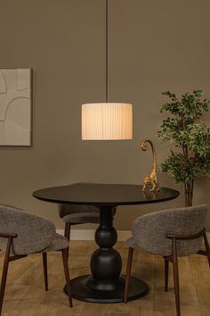 a dining room table with two chairs and a lamp