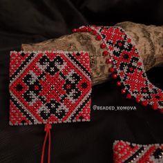 red and black beaded bracelets sitting on top of a piece of wood