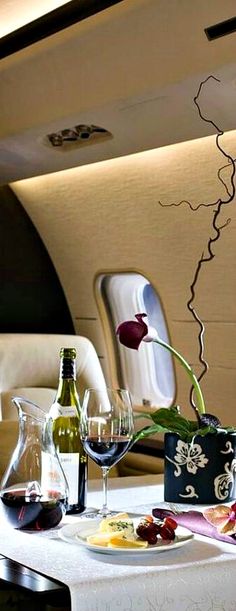 a table with wine, cheese and crackers on it in an airplane dining area