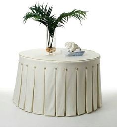 a white table with a plant on top