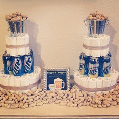 two stacks of beer cans stacked on top of each other in front of a table