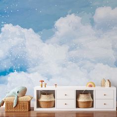 there is a wall mural with clouds and stars in the sky behind two wicker baskets