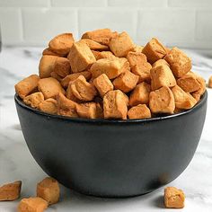 a black bowl filled with dog food on top of a table