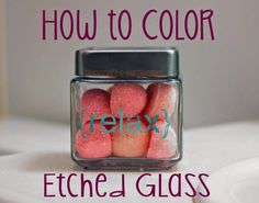 a glass jar filled with pink and green colored candies on top of a white counter