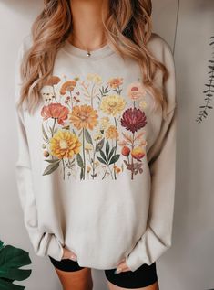 Introducing our vintage-inspired unisex sweatshirt adorned with a charming design of pressed fall flowers. Embrace the enchanting spirit of autumn with this minimalist masterpiece that celebrates the beauty of the season. The delicate and carefully crafted design captures the essence of fall, evoking feelings of warmth and nostalgia. This sweatshirt is a perfect blend of style and comfort, making it ideal for both outdoor adventures and cozy indoor moments. Wrap yourself in the softness of this sweatshirt and embrace the allure of autumn. The minimalist design of pressed fall flowers adds an elegant touch to any outfit, making it a must-have for your fall wardrobe. Find more information here: -50% cotton, 50% polyester -Medium-heavy fabric (8.0 oz/yd² (271.25 g/m -Loose fit -Runs true to s Retro Cotton Sweatshirt For Fall, Casual Printed Sweatshirt For Fall, White Floral Print Sweatshirt For Fall, Oversized Retro Sweatshirt For Spring, Retro Oversized Sweatshirt For Spring, Floral Print Long Sleeve Sweatshirt For Fall, Casual Fall Tops With Plant Print, Vintage Relaxed Fit Sweatshirt For Fall, Cottagecore Long Sleeve Tops For Fall