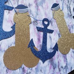 an anchor and sailor hat banner on a marble table with blue glittered paper streamers