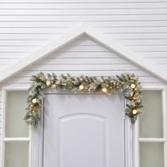 a white door decorated with christmas lights and garland