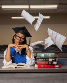 a woman sitting at a desk with books and papers flying in the air over her head