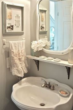 a white sink sitting under a bathroom mirror