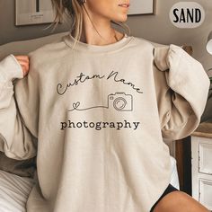 This sweatshirt is the perfect way to showcase your individual style while also promoting your brand. With the ability to write your own name, studio, or company name on the sweater, you can create a personalized and professional look that is sure to make an impact. Made from high-quality materials, this sweatshirt is designed to be both comfortable and durable, making it perfect for long days on the job. Whether you're shooting in the studio or out on location, this sweatshirt will help you look and feel your best. Whether you're shooting on location or attending a photography event, our custom photographer's sweater is the perfect way to show off your passion for photography while representing your brand.  CARE INSTRUCTIONS: ↬ Machine wash on warm ↬ Bleach as needed ↬ Tumble dry on mediu Personalized Casual Sweatshirt For Gifts, Product Photography Sweatshirt, Custom Name Cotton Sweatshirt For Gift, Photography Sweatshirt, Personalized Relaxed Fit Winter Sweatshirt, Photography Names, Gildan Sweatshirts, Professional Look, White Design