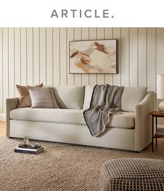 a living room scene with focus on the couch and rugs that are in front of the wall