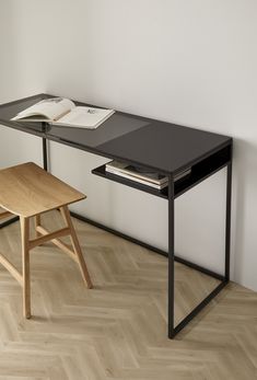 a desk with a book on it next to a chair