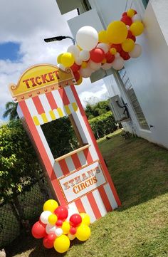 a carnival ticket booth with balloons and streamers