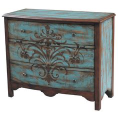 an old blue painted dresser with ornate designs on the front and side drawers, against a white background