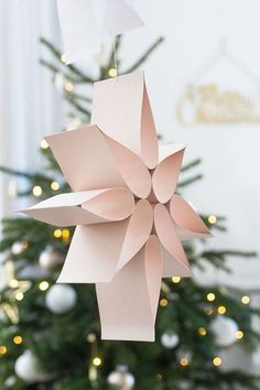 a paper origami flower hanging from a christmas tree