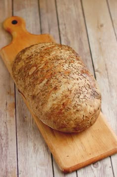 a loaf of bread sitting on top of a wooden cutting board