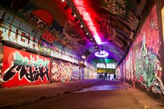 an empty tunnel with graffiti all over it