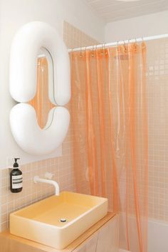 a bathroom with a sink, mirror and shower curtain