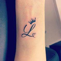 a small wrist tattoo with the letter l on it's left arm and a crown on top