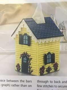 a small yellow house made out of crochet on a white surface with text describing it