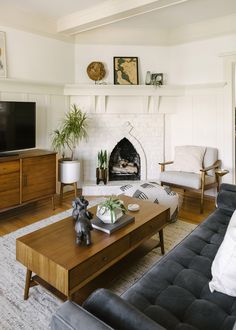 a living room filled with furniture and a flat screen tv mounted on a wall above a fire place