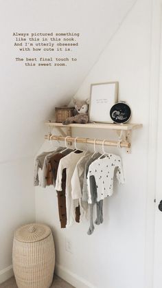 a baby's clothing rack with clothes hanging from it and a quote on the wall