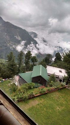 a green roof on top of a building with mountains in the background