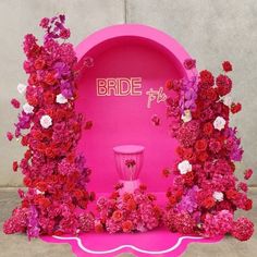 pink and red flowers decorate the entrance to a bride to be