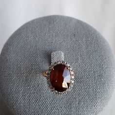 Gemporia Hessonite (Red) Garnet Ring. 8.42ctw Oval (14x10), Basket Setting. 20 Round White Topaz Stones In A Halo Around Garnet. Ring Is Yellow Gold Over 925 Silver, Weighs 4.3g. Size 6. This Is A Stunner! Exquisite Oval Gemstones With Accents, Oval Gemstones With Halo Setting For Formal Occasions, Oval Center Stone Gemstones For Formal Occasions, Oval Gemstones With Prong Setting For Formal Occasions, Elegant Oval Ruby Ring With Rose Cut Diamonds, Elegant Oval Gemstones With Accents, Exquisite Oval Gemstones For Formal Occasions, Exquisite Oval Gemstones For Formal Events, Oval Ruby Ring With Rose Cut Diamonds