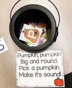 a bucket filled with pumpkins next to a sign that says pumpkin, pumpkin big and round pick a pumpkin make it's sound