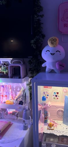 a stuffed animal sitting on top of a display case in a room filled with toys