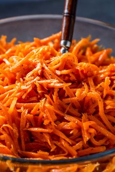 a bowl filled with shredded carrots on top of a table