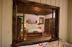 a bed sitting inside of a bedroom on top of a wooden floor next to a window