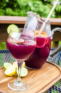 two glasses filled with liquid sitting on top of a wooden tray