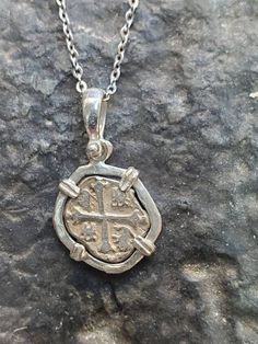 This is the silver recovered from the atocha, made from the silver bars and comes with a certificate and a free stainless steel chain. The frame around the coin is solid sterling silver. This size is about the size of a dime. Silver Cross Necklace With Coin Pendant, Silver Engraved Pendant Coin Necklace, Silver Engraved Coin Pendant Necklace, Nickel-free Silver Coin Pendant Necklace, Silver Sterling Silver Coin Necklace With Oxidized Finish, Silver Coin Shaped Stamped Necklace, Silver Coin-shaped Stamped Necklaces, Silver Coin-shaped Stamped Necklace, Silver Sterling Silver Coin Necklace