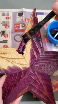 someone is painting a wooden star with acrylic paint