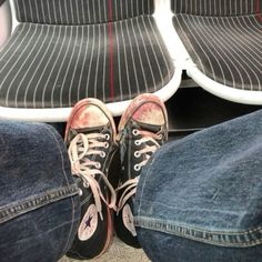 two pairs of shoes sitting on top of a seat next to another pair of jeans