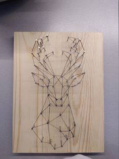 a deer head made out of string on a piece of plywood with a mouse next to it