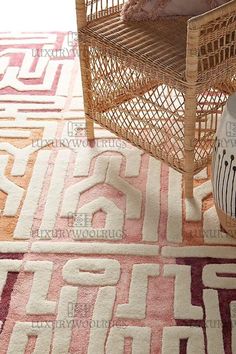 an area rug is shown on the floor in front of a wicker chair and side table