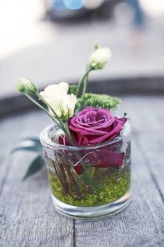 a glass vase filled with flowers on top of a wooden table