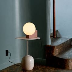 a table with a lamp on it next to some stairs