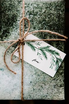 a present wrapped in twine with a tag tied to it's side on top of a stone slab