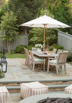 an outdoor dining area with patio furniture and umbrella