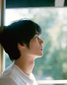 a young man is looking out the window