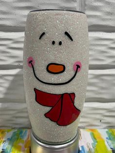 a white cup with a snowman painted on it