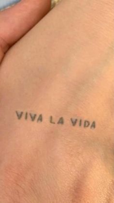 a woman's arm with the words viva la vita tattooed on her left side